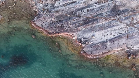 Drone view of layered rock formations and aquamarine shoreline along Lake Video stock 307285792