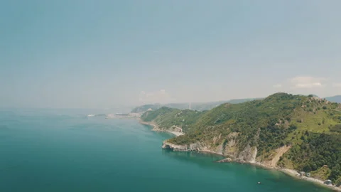 Drone view of the lighthouse in the trees, the white lighthouse building built Stock Footage 234098630