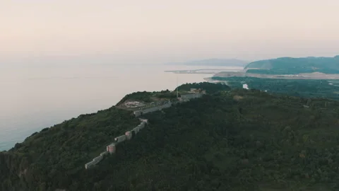 Drone view of the lighthouse in the trees, the white lighthouse building built Stock Footage 234098796