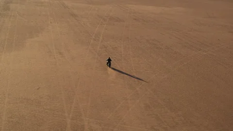 Drone view of a lone motorcycle in the desert and its silhouette Stock Footage 264075246