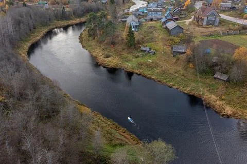 Drone view of a lone paddleboarder navigating a curved river past a rural Stock Photos