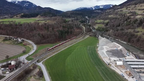 Drone view of long train on railway near factory and green field 스톡 동영상 330749138