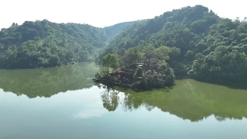 Drone View of a Lush Green Hill Beside a Calm, Peaceful Lake Stock Footage 309918521