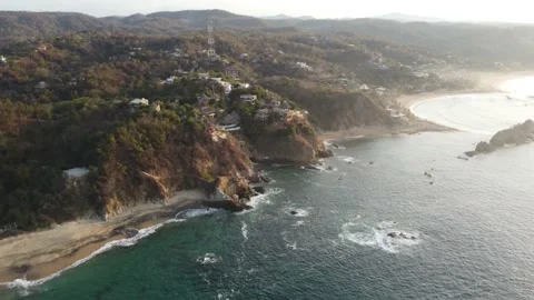 Drone view of majestic rock formations rise from the sparkling ocean Stock Footage 234274059
