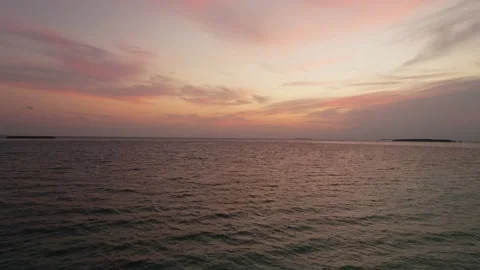 Drone view of Maldives sunset over calm ocean, panoramic pink sky and island Stock Footage 166515033