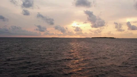 Drone view of Maldives sunset over calm ocean, panoramic pink sky and island Stock Footage 168254308