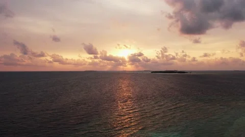 Drone view of Maldives sunset over calm ocean, panoramic sky and island 動画素材 168318986