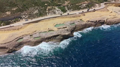 Drone view of Maltese salt pans forming geometric pools along the Gozo coast Stock Footage 335837053