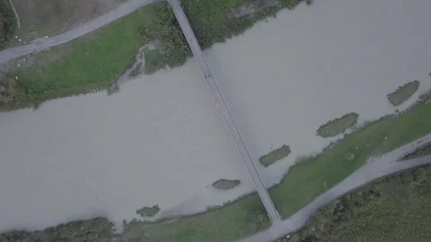 Drone View Of Man On Bicycle Riding On Bridge Stock Footage 264270567