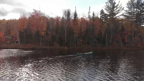 Drone view of a man in a canoe on a lake in Quebec during autumn season Stock Footage 104374545