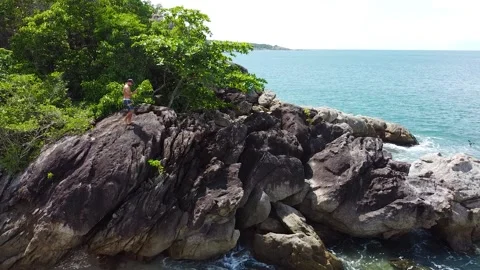 A drone view of a man climbing and jumping from rock to rock Stock Footage 171337406