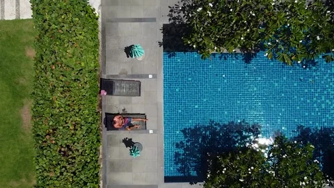 Drone view of man relaxing by pool Stock Footage 172475087