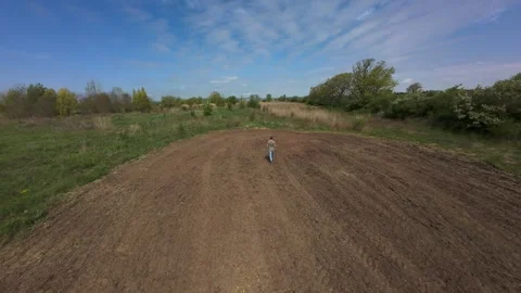 Drone view of a man walking and spreading seeds by hand on a food plot Stock Footage 341757701