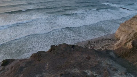 Drone view of man walking next to the cliffs in Portugal Stock Footage 126351826