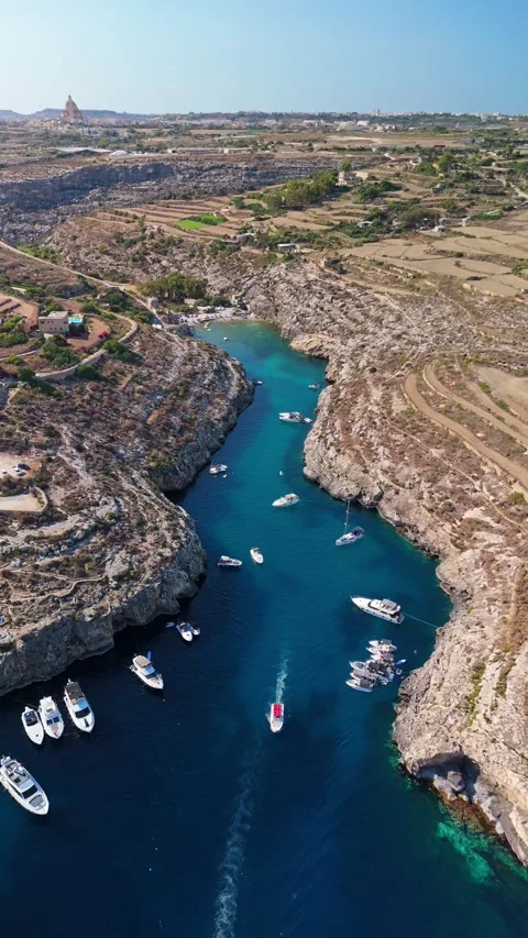 Drone view of Mġarr ix-Xini bay, Gozo with yachts by rocky cliffs and beach Stock Footage 341712330