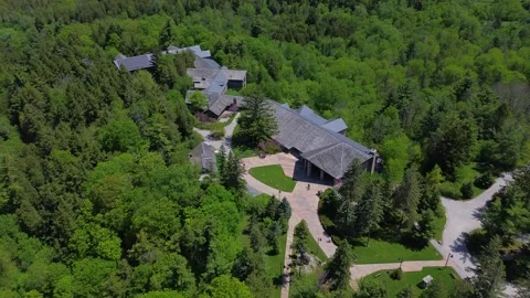 Drone view of the McMichael Canadian Art Collection surrounded by tall trees 스톡 동영상 335797995