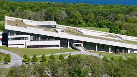 Drone view of a modern, angular building complex nestled in a wooded area. Vídeos de archivo 320429162