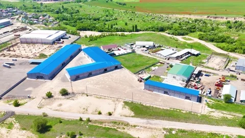 Drone View of Modern Warehouse Complex Surrounded by Green Landscape Stock Footage 340041556