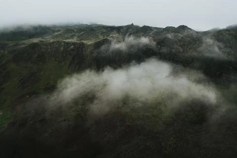 Drone view of a mountain above the clouds on a foggy day, Iceland. Stock Photos