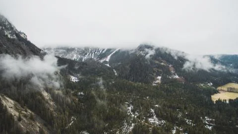 Drone view of a mountain hillside with pine trees above the clouds  Stock Photos