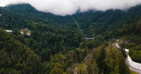 Drone view of a Mountain Road Through Foggy Peaks Stock Photos