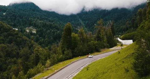 Drone view of a Mountain Road Through Foggy Peaks Stock Photos