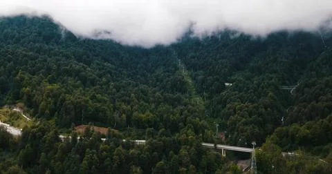 Drone view of a Mountain Road Through Foggy Peaks Stock Photos