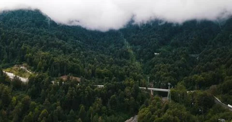 Drone view of a Mountain Road Through Foggy Peaks Stock Photos