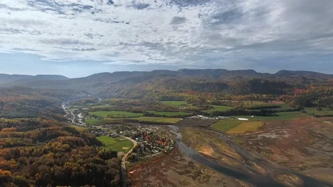 Drone view mountains with dense forest, fields, a small town and a calm pond Video stock 120646815