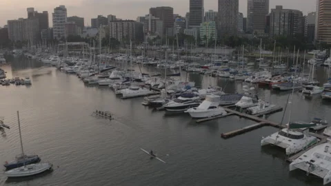 Drone view moving over canoeists and moored boats to city Video stock 239486198