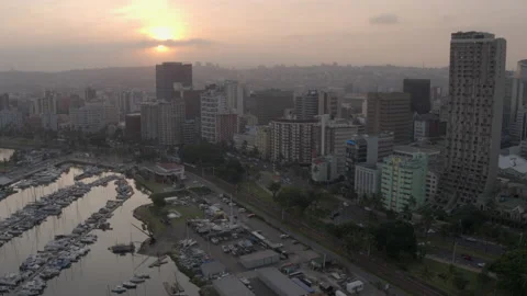Drone view moving from the setting sun to yacht club and Durban's skyline Video stock 239487784