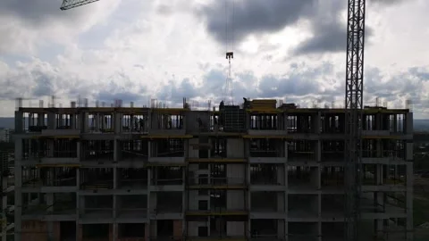 Drone view of a multi-story concrete building under construction with workers an 库存影片 323239401