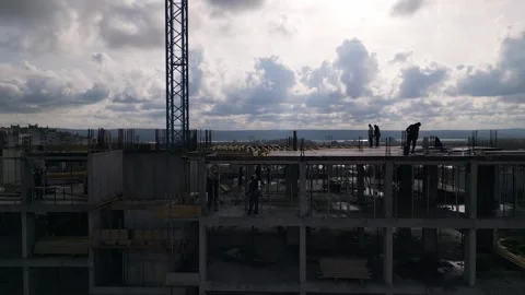 Drone view of a multi-story concrete building under construction with workers an Stock-Footage 323240994