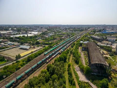 Drone view of multiple freight train lines with green and brown cargo wagon.. Photos