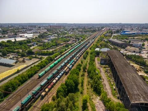 Drone view of multiple freight train lines with cargo wagons at industrial .. Stock Photos