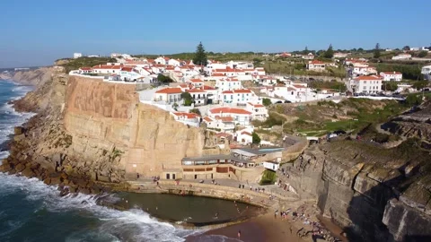 Drone view of a natural pool in the ocean next to the cliff and village Stock Footage 176802076