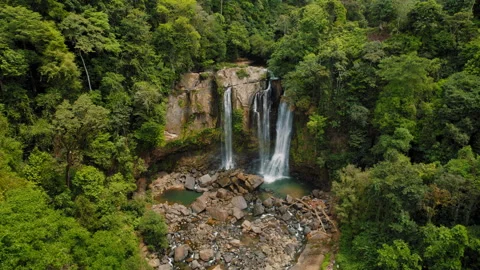 Drone view of Nauyaca waterfall surrounded by dense green jungle in Costa Rica Stock Footage 320537762