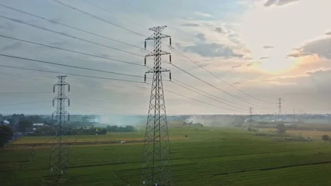 Drone view of a newly constructed electric transmission tower on a green rice Stock Footage 141638100