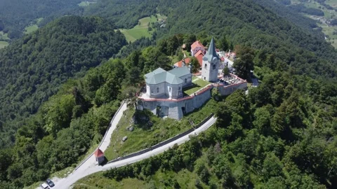 A drone view of an old church located on a hill. Camera slowly moves away fr Stock Footage 247120215