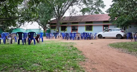 Drone view of old house or school with red tile roof and empty plastic chai.. Video stock 319389106