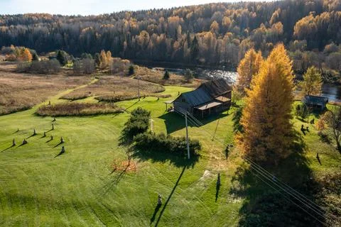 Drone view of an old rustic wooden house with a large green lawn and Stock Photos