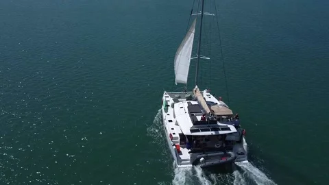 A drone view of the opening of the sail on a sailing catamaran Stock Footage 218175410