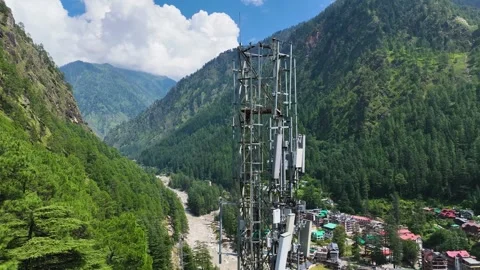 Drone view orbiting a high-altitude telecom tower above an off-grid village 動画素材 345274783