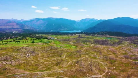 Drone view over a broad alpine basin with rolling hills golf course greens Stock Footage 333402678