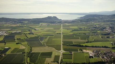 Drone View over Fields and Roads with Lake Garda and Garda Town, Italy Video stock 316760977