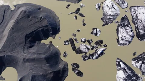 Drone view over murky glacier lake with chunks of ice with volcanic ash Stock Footage 340198814