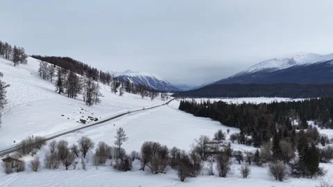 Drone view over snowy road through mountain valley in Xinjiang Stock Footage 336597129