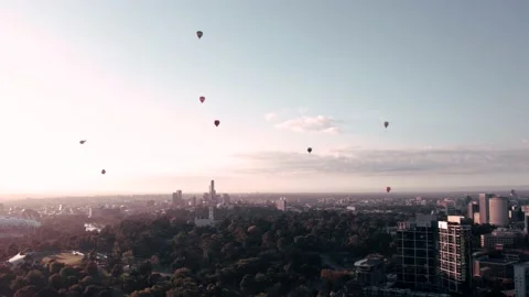 Drone view of the parachutes floating in the sky over the city with many trees a Stock Footage 231130906