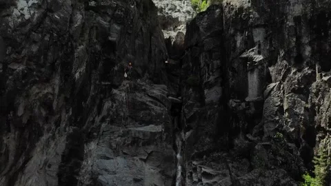 Drone view of people abseiling and canyoning transitioning to high bird view of Stock Footage 201525397