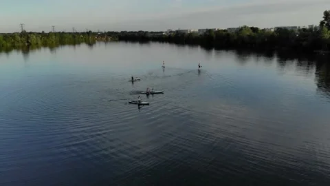 Drone view of people floating on a sub board on a blue lake Видео 155999939